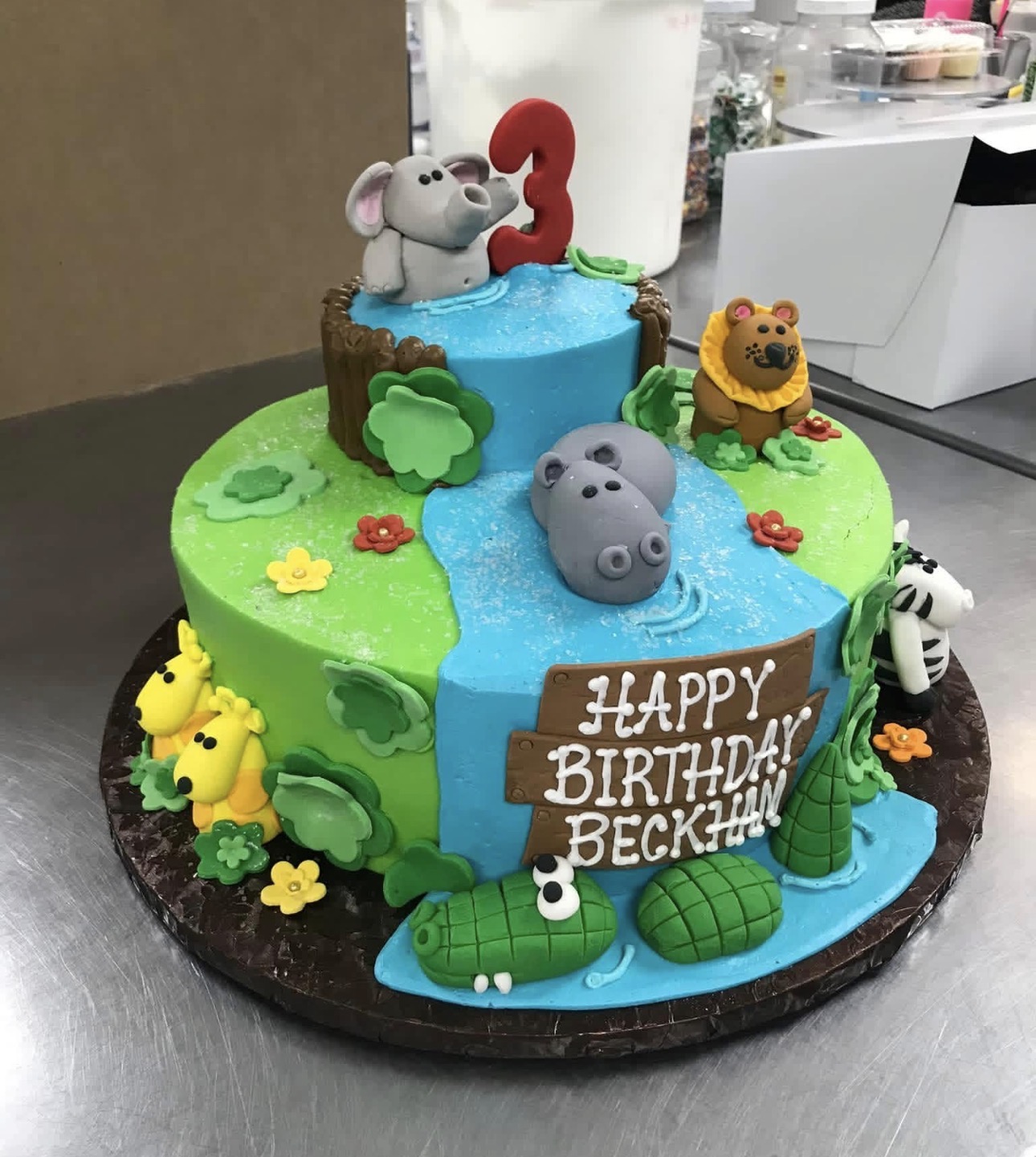 Jungle safari birthday cake with fondant elephant, hippo, lion and giraffes